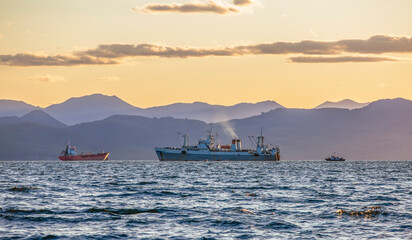 large fishing vessel on the background of hills and volcanoes in Kamchatka Peninsula