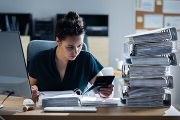 Young Businesswoman Working At Office With Stack Of Folders - obrazy, fototapety, plakaty