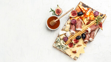 Cheese platter. Assorted cheese, ham, fruit, bread sticks, nuts. banner, menu, recipe place for text, top view