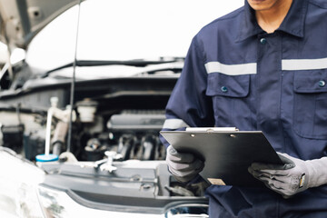 Hand of car mechanic with wrench. Auto repair garage. mechanic works on the engine of the car in the garage. Repair service. Concept of car inspection service and car repair service.