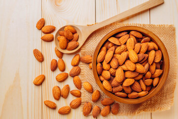 Almond top view on wooden table with wooden spoon or scoop Almonds in a wooden bowl The nuts are...