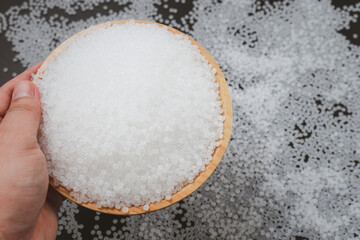 White plastic beads on wood  background, Polymers bead or polymer resin, polymer pallet, Product from petrochemical plants. granules polymer,