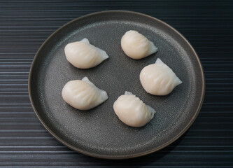 Fototapeta na wymiar steamed har gao prawn wrapped in crystal skin dumpling on dark grey wood background dim sum menu