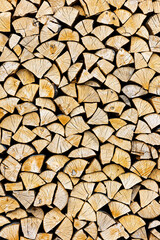 Stacked chopped wood close-up texture. Firewood storage background. Stocks of wooden logs. Chopping wood for a fireplace. Woodpile with firewood with visible wooden texture.