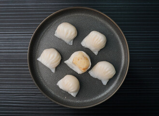 steamed har gao prawn wrapped in crystal skin dumpling on dark grey wood background dim sum menu