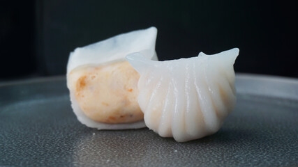 steamed har gao prawn wrapped in crystal skin dumpling on dark grey wood background dim sum menu