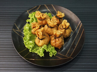 steamed bean curd skin wrapped with meat ball fortune bag dumpling on dark grey wood background dim sum menu