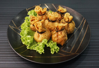 steamed bean curd skin wrapped with meat ball fortune bag dumpling on dark grey wood background dim sum menu