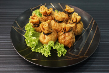 steamed bean curd skin wrapped with meat ball fortune bag dumpling on dark grey wood background dim sum menu