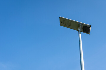 Solar cell panel LED lighting pole on blue sky background.