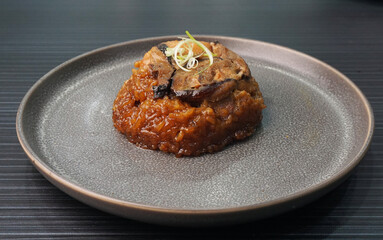 handmade steamed lomaigai sticky glutinous rice with chicken and mushroom on dark grey wood background Hong Kong dim sum menu