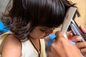 portrait of cute baby girl during haircutting.