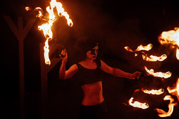 a dangerous and beautiful fireshow in the dark. artists in costumes of mythological creatures hold...
