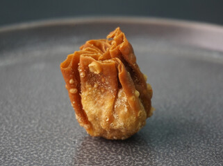 handmade deep fried and boiled pork meat dumpling wanton soup on dark grey wood background dim sum...