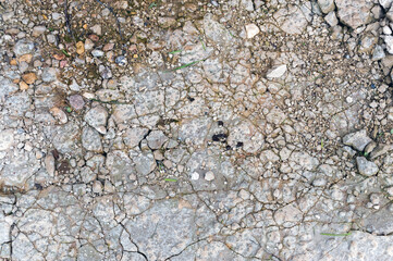 Concrete background with cracks and stones