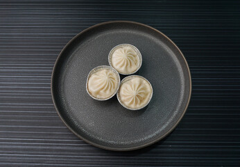 handmade steamed Shanghai Xiao long bao pork meat dumpling soup on dark grey wood background dim sum menu