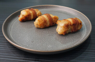 deep fried pork meatball wrapped with bacon roll on dark grey wood background dim sum menu