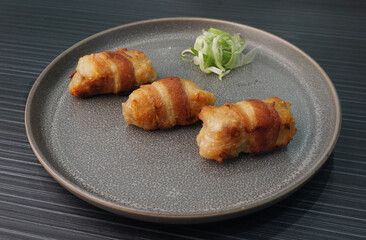 deep fried pork meatball wrapped with bacon roll on dark grey wood background dim sum menu