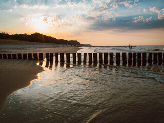 Fototapeta premium Baltic seascape with wooden wave breaker at sunset