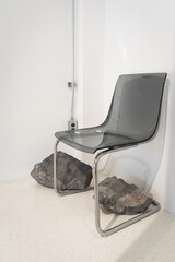 Modern transparent black chair chrome structure metal and rock on ceramic floor with white wall...