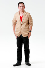 Portrait of Asian happy relax middle aged male model wearing eyeglasses standing look at camera put hands in pant pockets in front white background