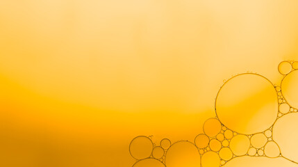 Abstract oil and water droplets on gold-orange gradient background.