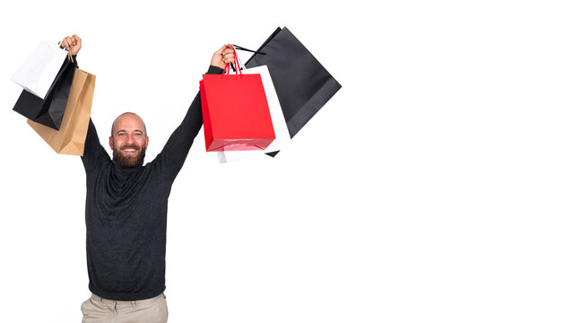 Happy and smiling young man with beard holding shopping bags.Horizontal banner image. Isolated on white background. Looking at camera.Copy space.