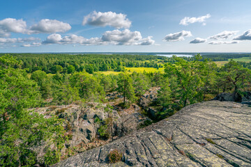 Beautiful summer day in Swedish landscape of Segersgarde nature reservation. Green forests, meadows view from the top of the rock. Summer holiday in Sweden. © Petr