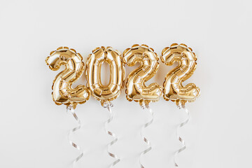 Foil balloons in the form of numbers 2022. New year celebration. Gold and silver Air Balloons. Holiday party decoration.