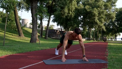 muscular man doing pushups with clapping on fitness mat with naked body, triceps
