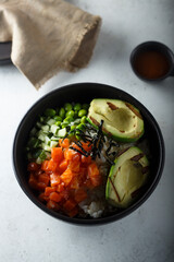 Healthy rice bowl with salmon and grilled avocado