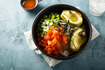 Healthy rice bowl with salmon and grilled avocado