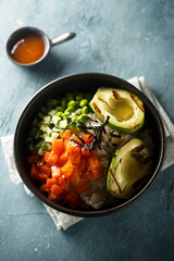 Healthy rice bowl with salmon and grilled avocado