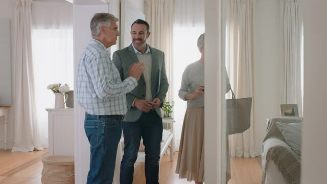 real estate agent showing mature couple new house presenting property investment happy clients shaking hands with realtor successfully purchasing home 4k footage