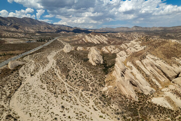 aerial scenic picture of desert mountains and highway on a beautiful sunny cloudy day
