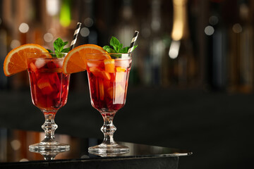 Delicious sangria cocktail on black table in bar. Space for text