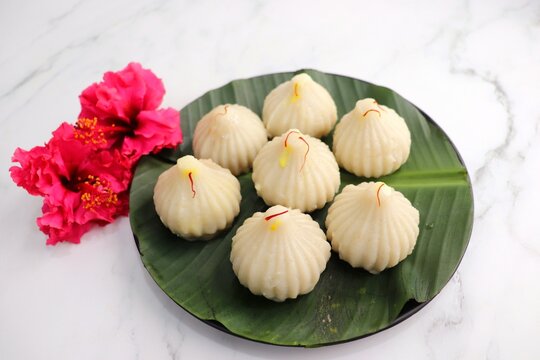 Steamed or ukdiche Modak. It's a traditional sweet dish made out of coconut, jaggery and dry fruits stuffed inside rice dough. Offered to Lord Ganesha during Ganpati festival in India. with copy space