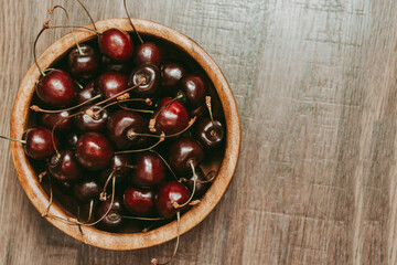 Ripe sweet red cherries on a wooden background. View from above.