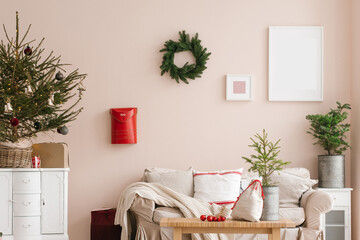Stylish Christmas living room interior with sofa, tree and wreath, mailbox, gifts and decorations. Festive time for the family.
