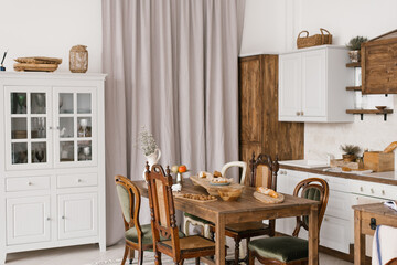 Kitchen table with food and kitchenware with a variety of wooden chairs in the Scandinavian style