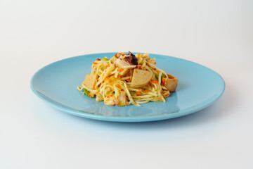 Green papaya salad in ceramic blue plate isolated on white background.