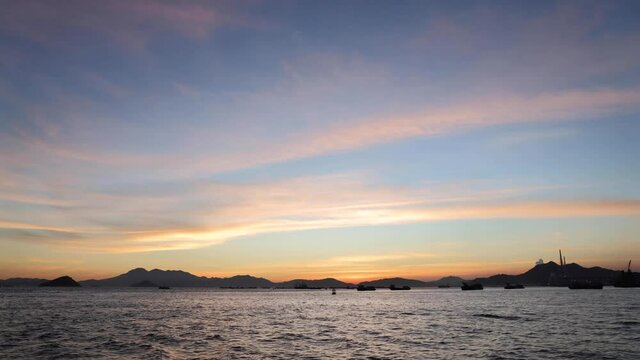 time lapse of clouds and boats moving around Victoria harbour, Hong Kong during sunset. photo from West Kowloon Promenade
