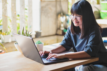 Fototapeta premium asian teenager working on computer laptop in living room