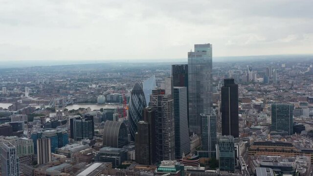 Aerial view of skyscrapers in business centre. Cityscape and Tower Bridge over Thames river in background. London, UK