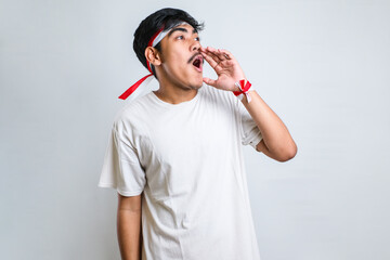 man wearing red and white headband shouting and screaming loud to side