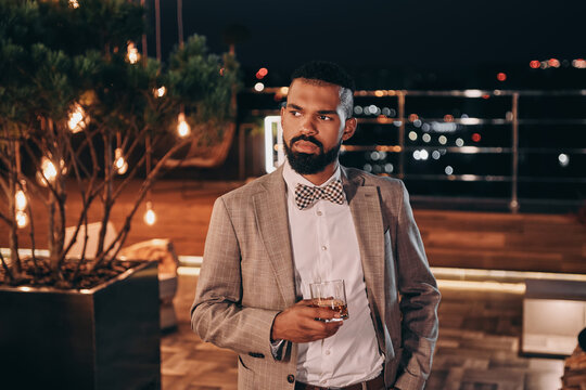 Handsome Young African Man In Suit Drinking Whiskey While Spending Time On Party