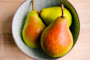Ripe pear on the plate on wooden background . High quality photo