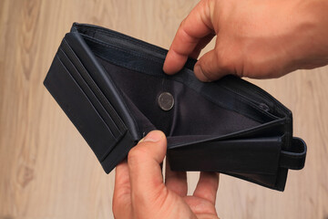 Man hand open leather wallet with one-shekel coin.