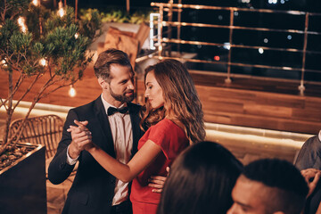 Beautiful young people dancing and smiling while spending time on luxury party