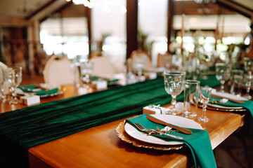 Beautiful decorated table for the event in the restaurant in emerald color. Wedding, birthday, party, event concept.